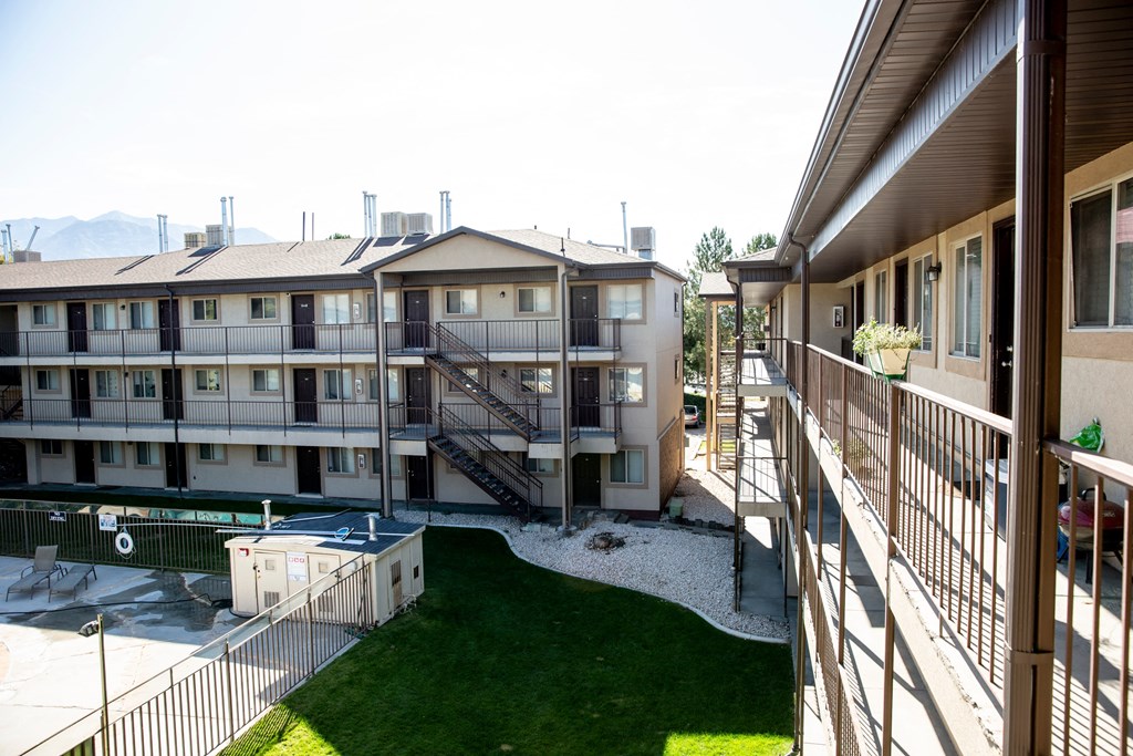 the view from the balcony of an apartment building with a pool