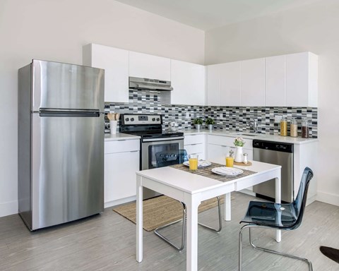 a kitchen with a table and a refrigerator
