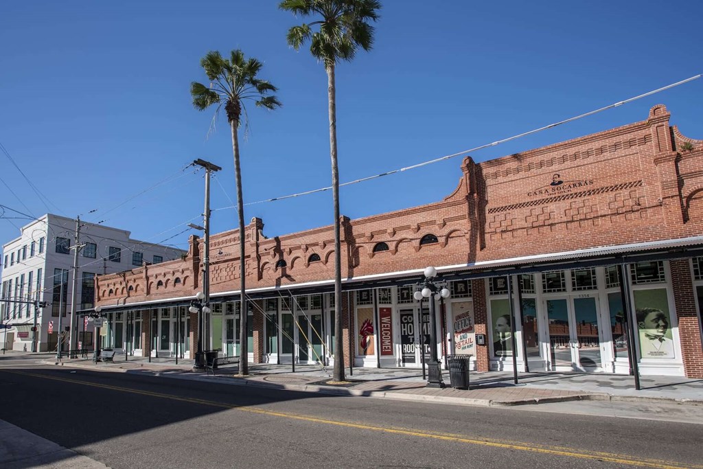 a building on a city street with palm trees