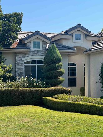 a house with a yard and a tree in front of it