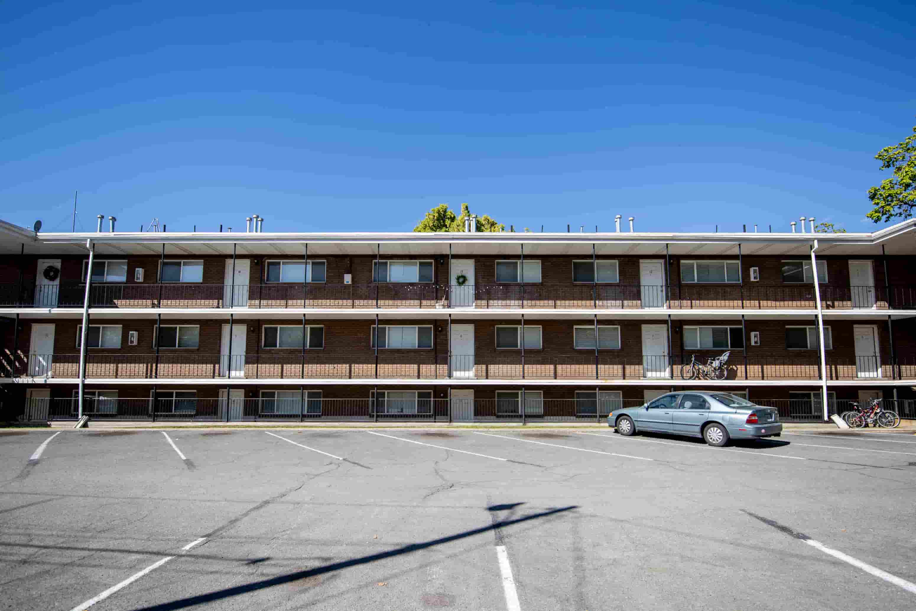 an empty parking lot in front of an apartment building