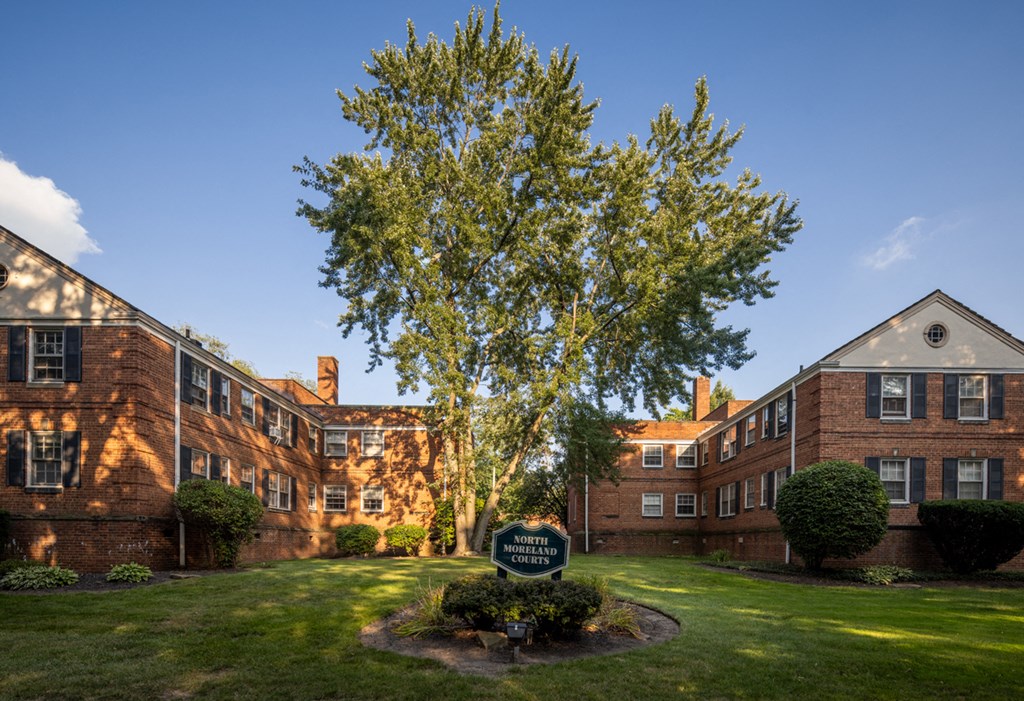 a large brick building with a tree in front of it