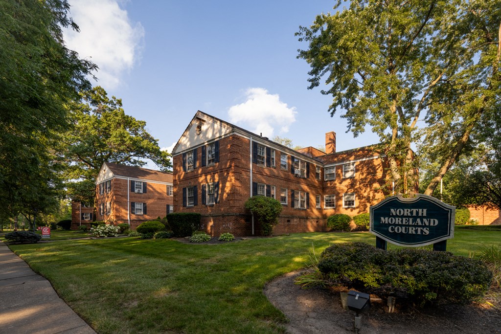 the front of a brick building with a green sign courts