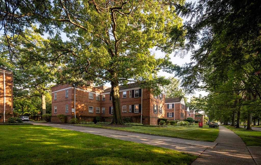 a row of brick apartment buildings on the side of a sidewalk