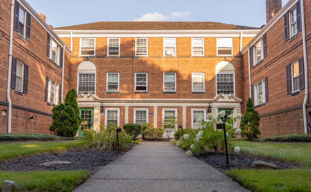 the front of a red brick building with a sidewalk