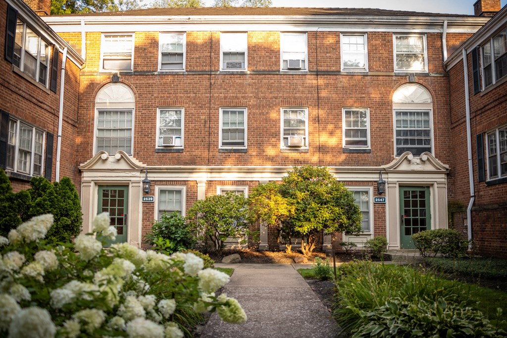 a view of the outside of a brick building with a garden