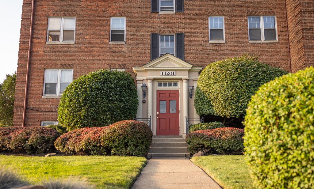 the front of a red brick building with a red door
