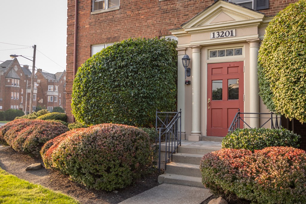 the front door of a brick building with a red door