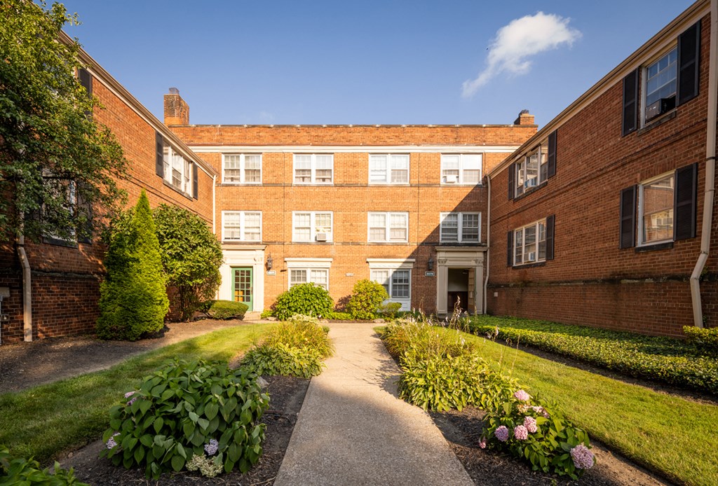 the courtyard of a brick building with a path in front of it