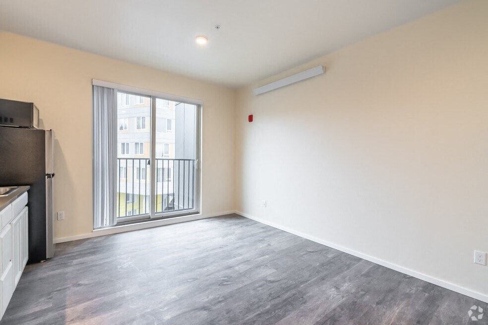 an empty living room with a large window and a balcony