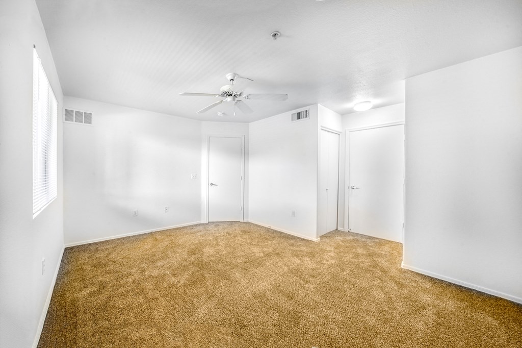 an empty room with white walls and white doors and a ceiling fan