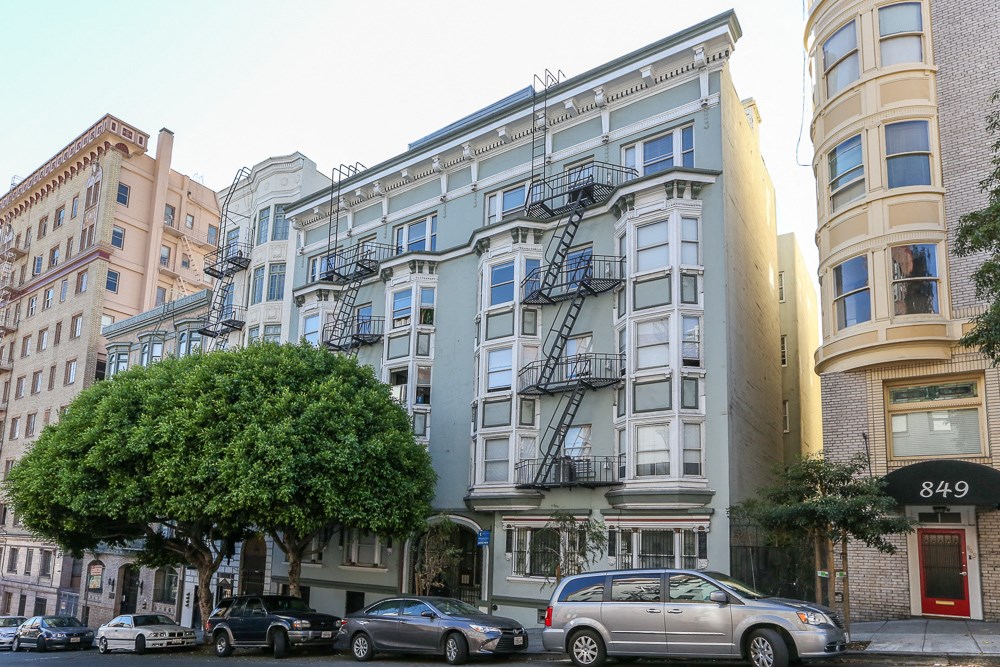 a city street with cars parked in front of a building