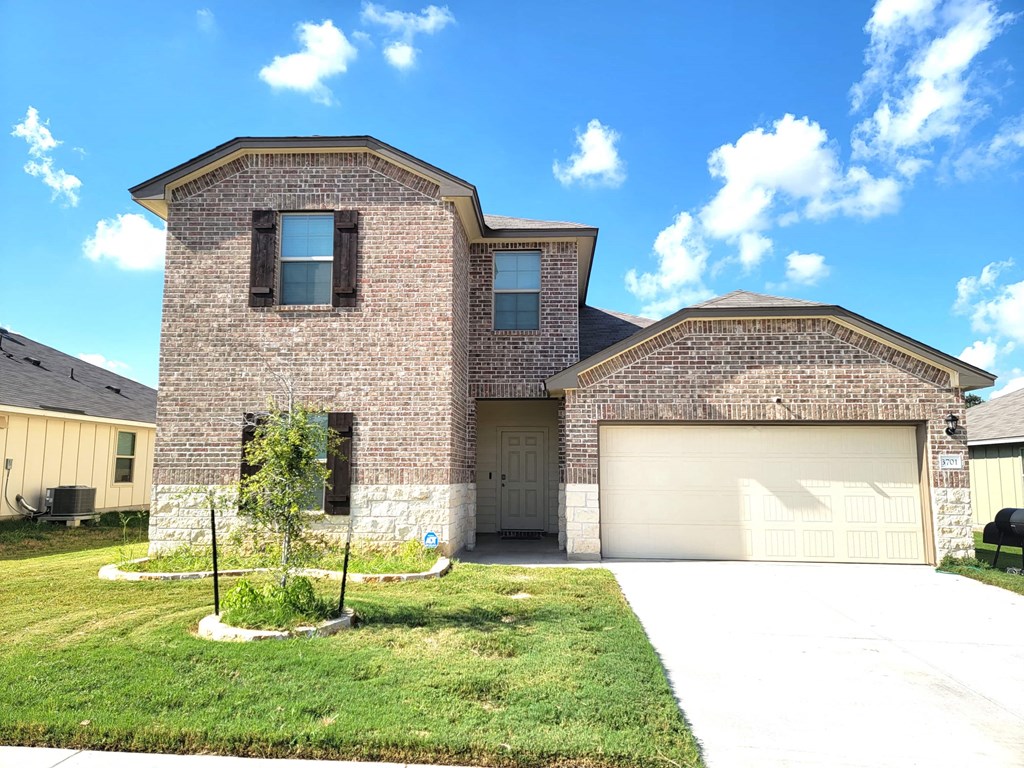 a large brick house with a garage and a lawn