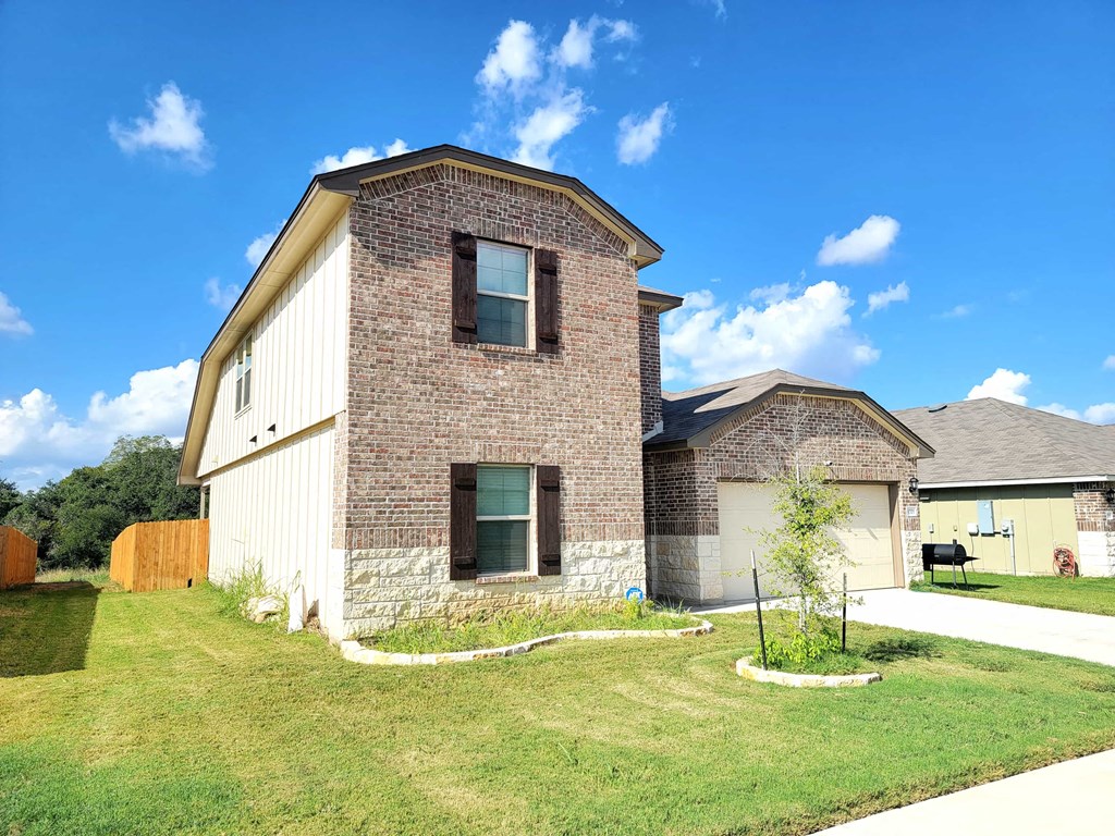 a brick house with a grassy yard in front of it