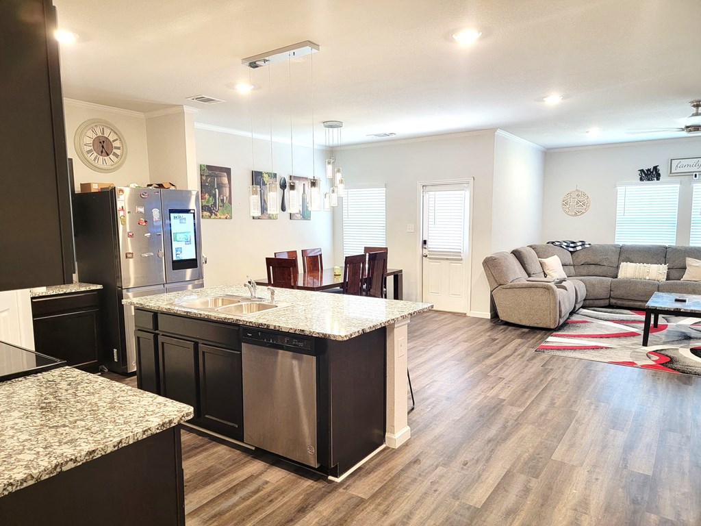 the view of the living room from the kitchen and dining room of a new home
