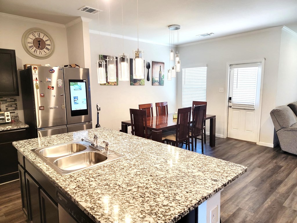a kitchen with a granite counter top and a stainless steel refrigerator