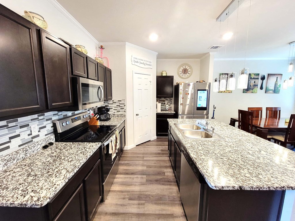 a large kitchen with granite counter tops and stainless steel appliances