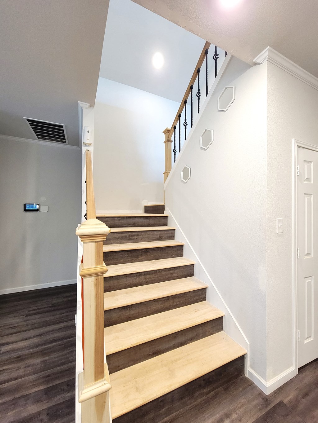 the landing of a staircase in a home with wood floors and white walls