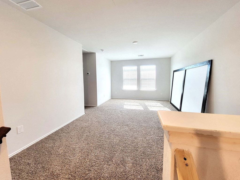 a large empty room with white walls and a wooden table