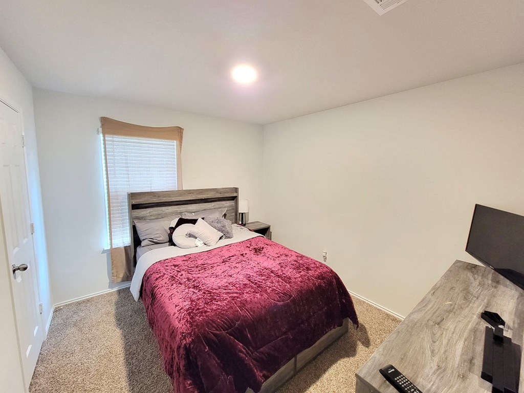 a bedroom with a bed and a window