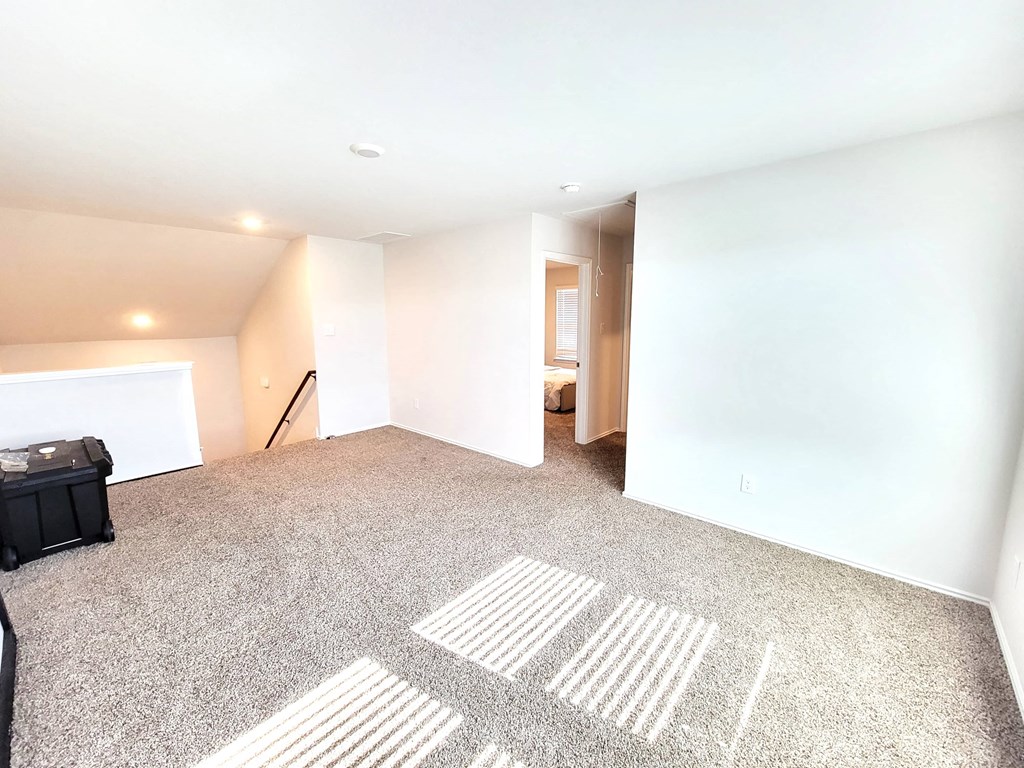 an empty living room with a white wall and carpet