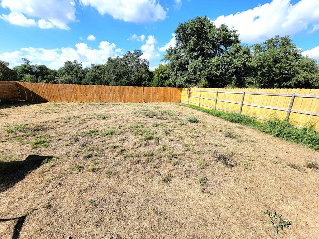 a backyard with a fenced in yard and a wooden fence