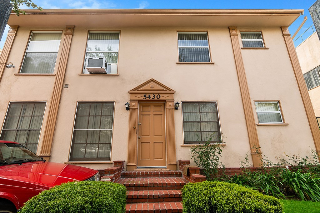 a house with a red car parked in front of it