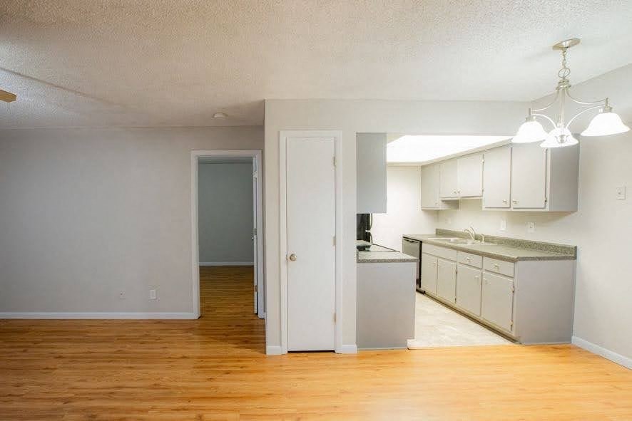 A kitchen area with a refrigerator and cabinets.