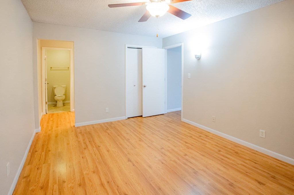 A room with a wooden floor and a ceiling fan.
