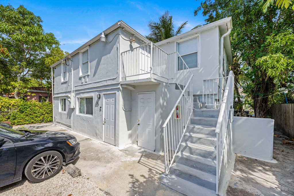 A two-story house with a car parked in front.