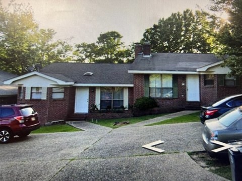 A house with a red car and a silver car parked in front.