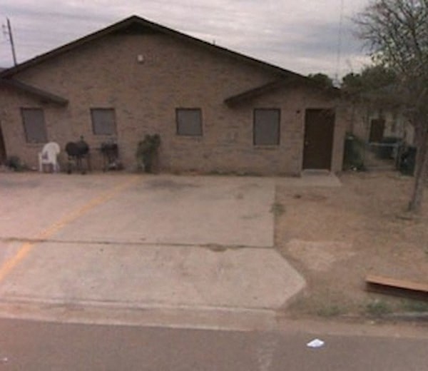 a brick house with a horse standing outside of it