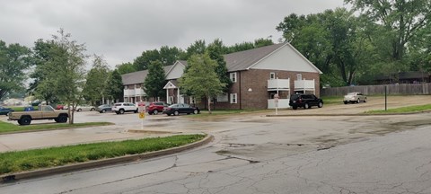 A parking lot with cars and a building in the background.