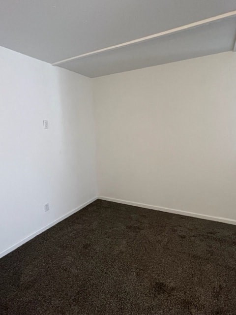 an empty room with a brown carpet and white walls