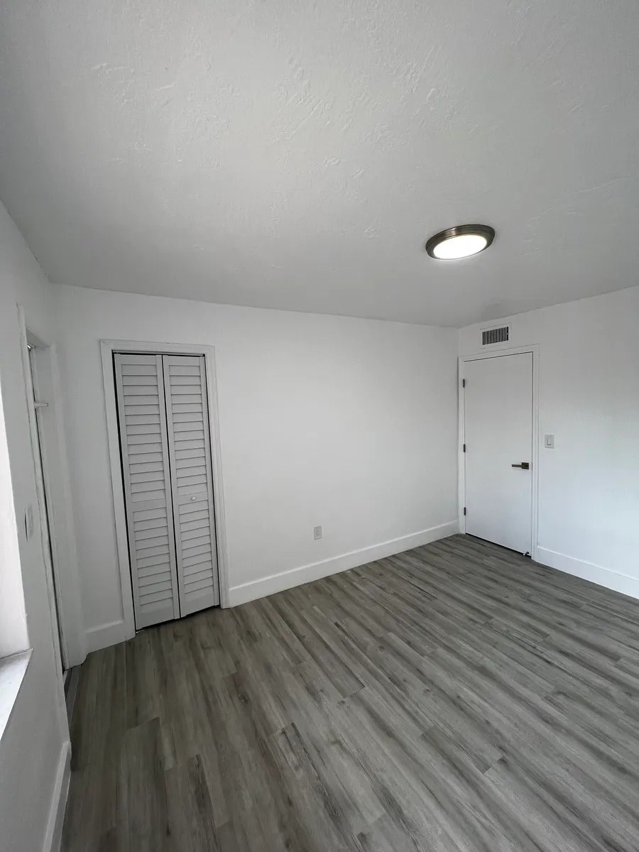 A room with a sliding door and a wooden floor.