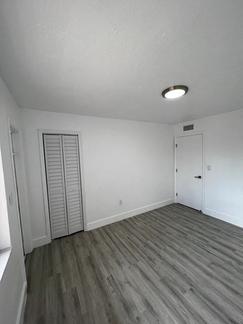 A room with a sliding door and a wooden floor.