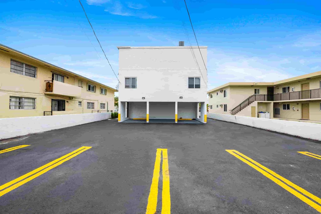 A parking lot with a white building in the background.