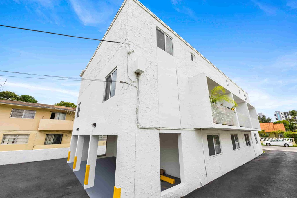 A white building with yellow accents and a clear blue sky in the background.