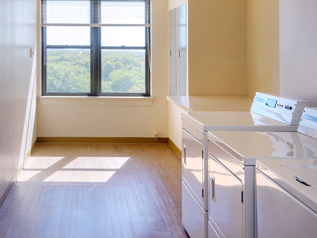 an empty kitchen with white cabinets and a window