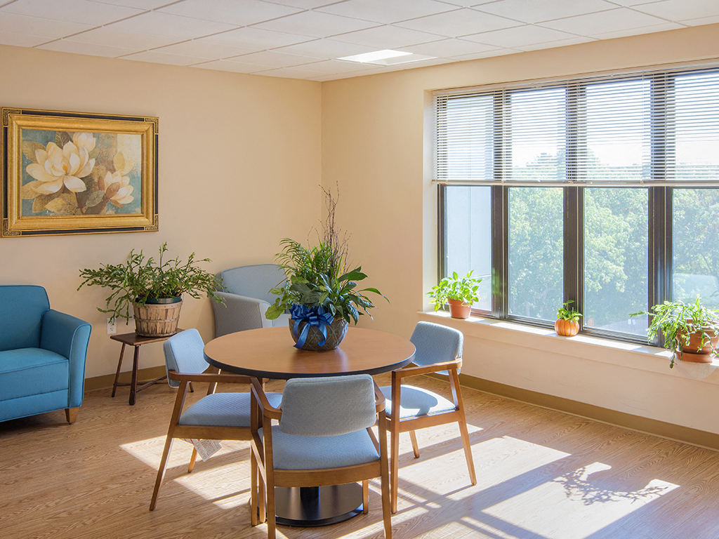 a dining room with a table and chairs and plants