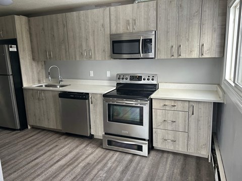 A kitchen with a stove, oven, microwave, and refrigerator.