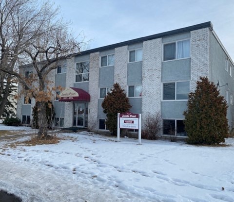 an apartment building with a sign in the snow