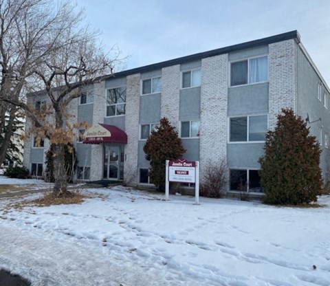 A building with a sign that says "Jamie Court" in front of it.