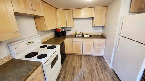 a kitchen with white appliances and wooden cabinets