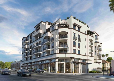 A large white building with balconies and multiple stories.