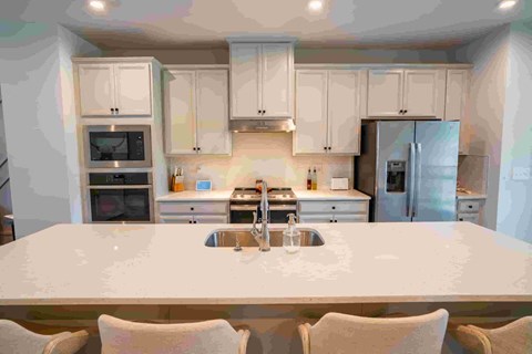 a kitchen with white cabinets and a white counter top