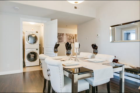 A modern dining room with a white table and chairs.
