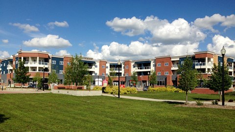 A large building complex with a green lawn in front.