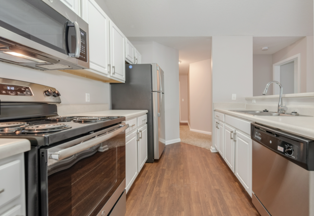 a kitchen with stainless steel appliances and white cabinets