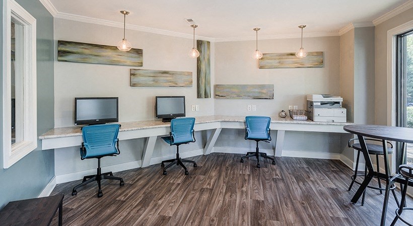 a break room with three computers and a table with chairs